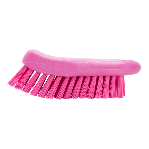 A close-up of a Carlisle Sparta pink handheld scrub brush with bristles.