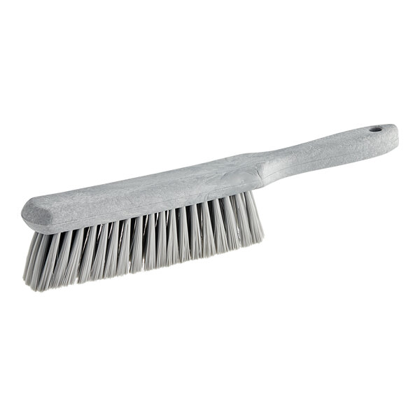 A close-up of a Carlisle Sparta gray soft polyester counter brush with a white handle.