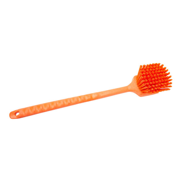 An orange plastic Carlisle Sparta pot scrub brush with bristles.