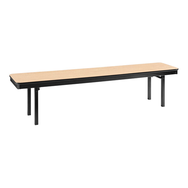 A National Public Seating Fusion Maple plywood bench with black T-mold edges on a long wooden table with black legs.