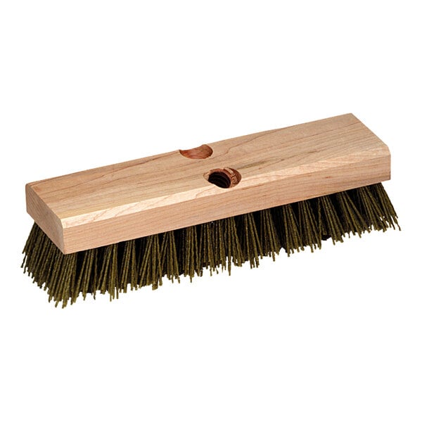 A Carlisle wooden deck scrub brush with green bristles.