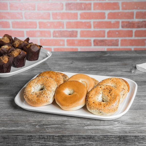 A white Eco-Products compostable sugarcane tray with bagels and muffins on it.