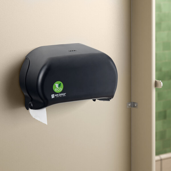 A black San Jamar Versatwin EcoLogic double roll toilet tissue dispenser on a wall.