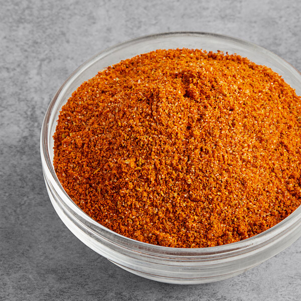 A bowl of Old Bay seasoning on a gray surface.