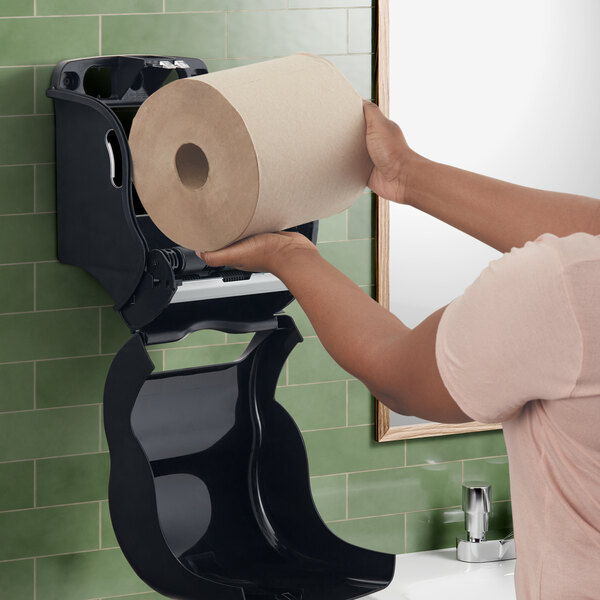 A woman's hand holding a San Jamar black roll towel.