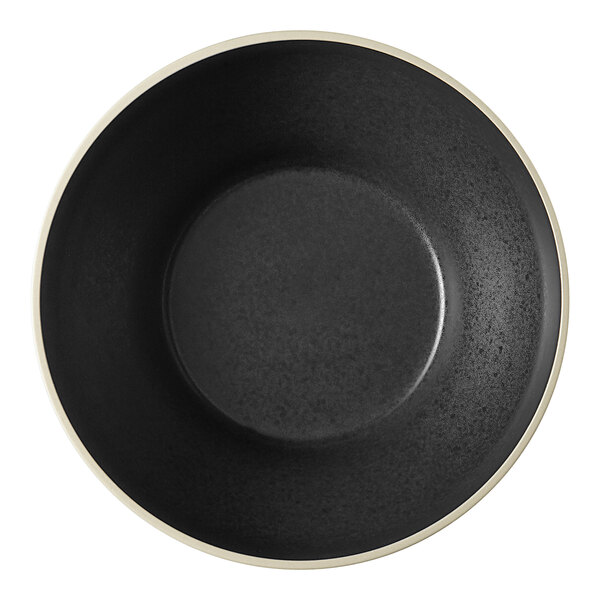 A black stoneware bowl with a white rim.