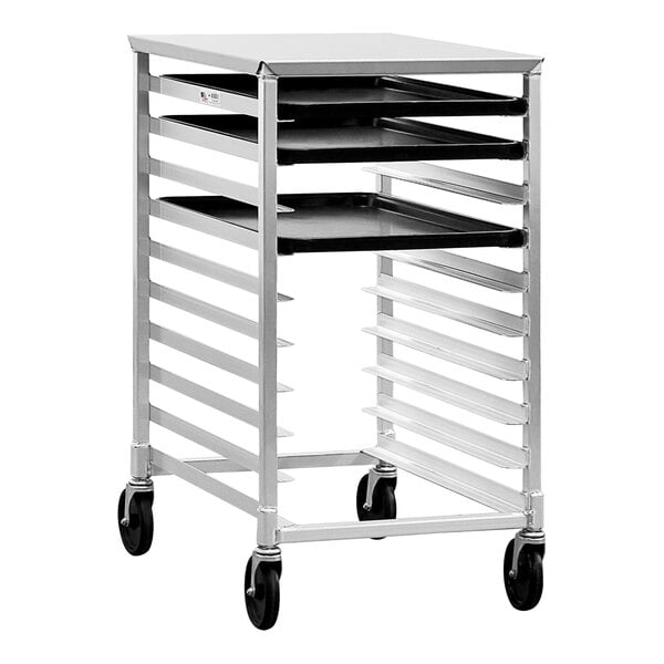 A New Age metal sheet pan rack with black trays on wheels.