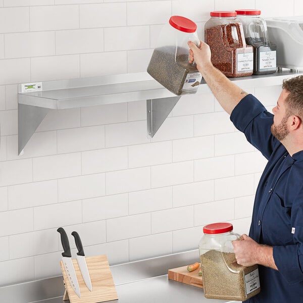 A man pouring salt onto a Regency stainless steel wall shelf.