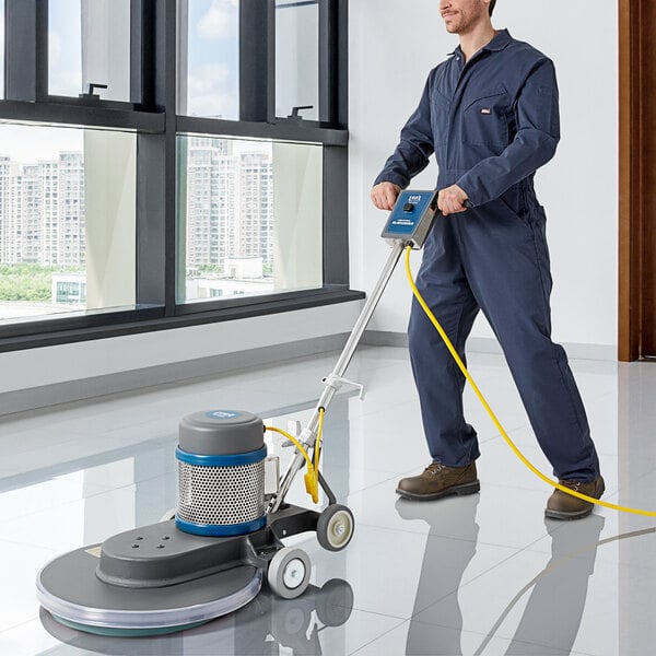 A man in overalls using a Lavex Pro heavy-duty floor burnisher to polish a floor.