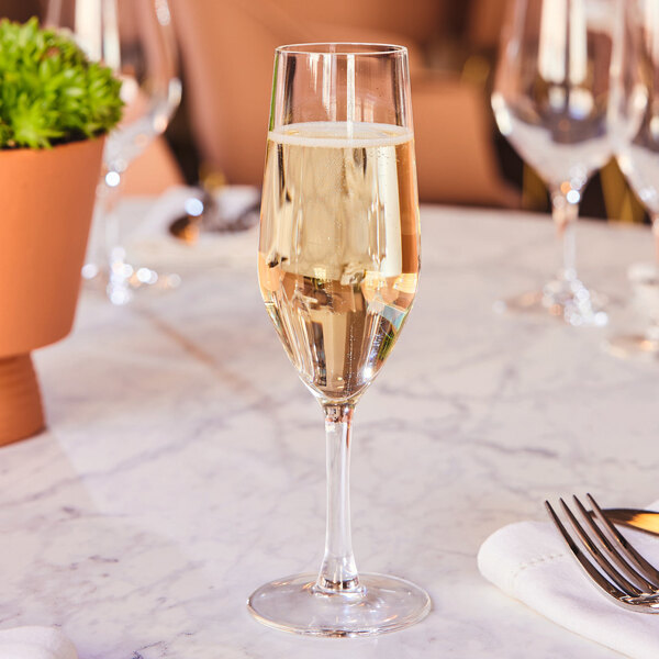 A glass of champagne sits on a table.