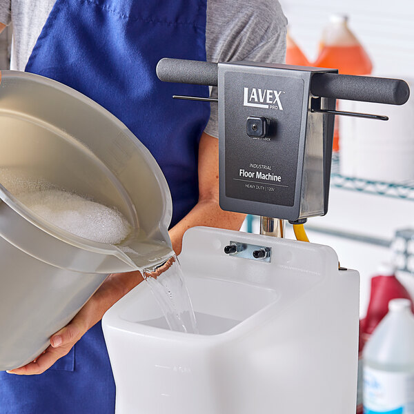 A man pouring water into a white rectangular container.