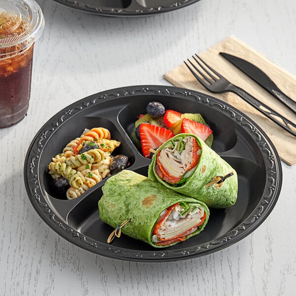 A black Ecopax 3-compartment plate of food with a drink.
