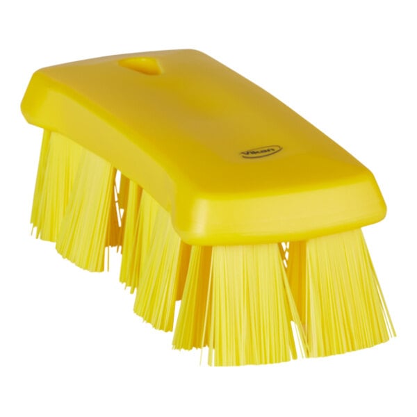A yellow Vikan hand brush with stiff bristles.