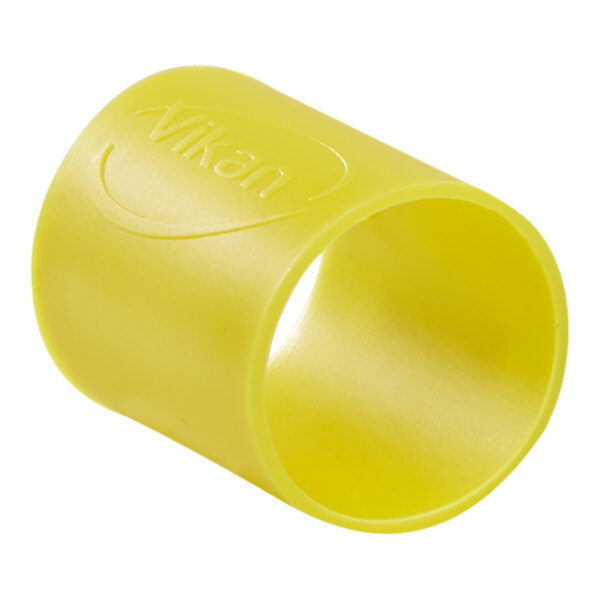 A close up of a yellow rubber band with a hole in it.