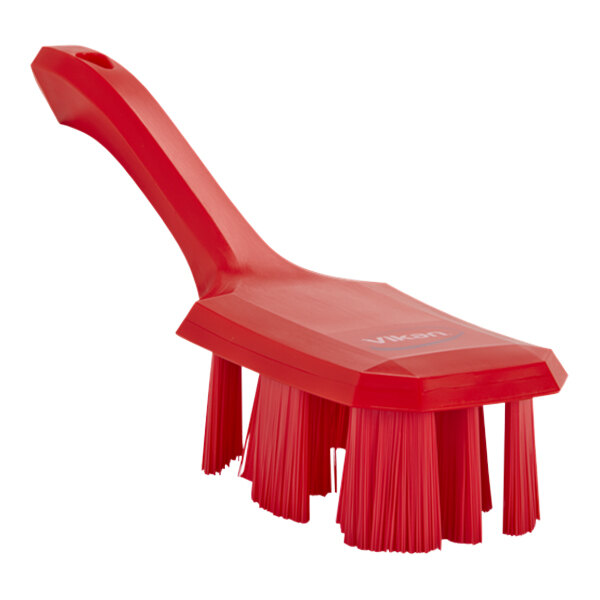 A red Vikan hand brush with stiff bristles and a short handle.