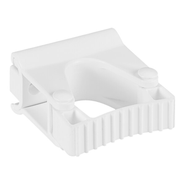 A close-up of a Vikan white plastic wall bracket with holes.