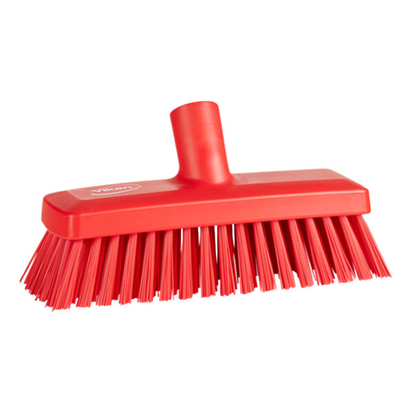 A close-up of a red Vikan deck scrub brush head with stiff bristles.