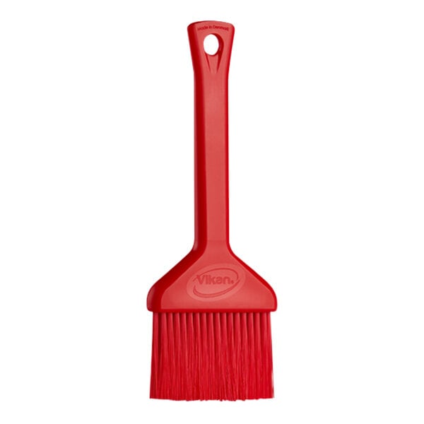 A red plastic Vikan pastry brush with a handle.