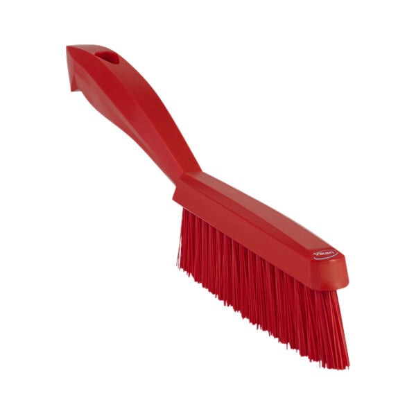 A close-up of a Vikan red narrow hand brush with a short handle.