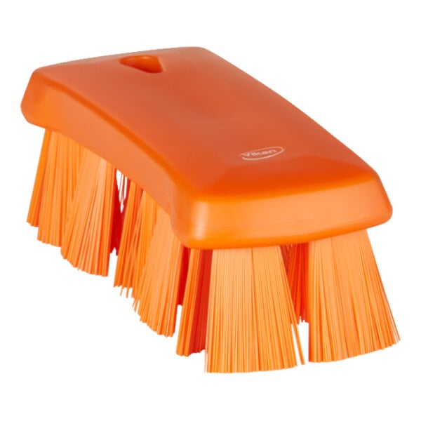 An orange Vikan hand brush with stiff bristles.