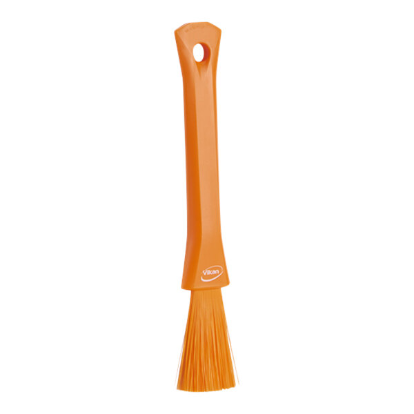 An orange Vikan detail brush with a handle.