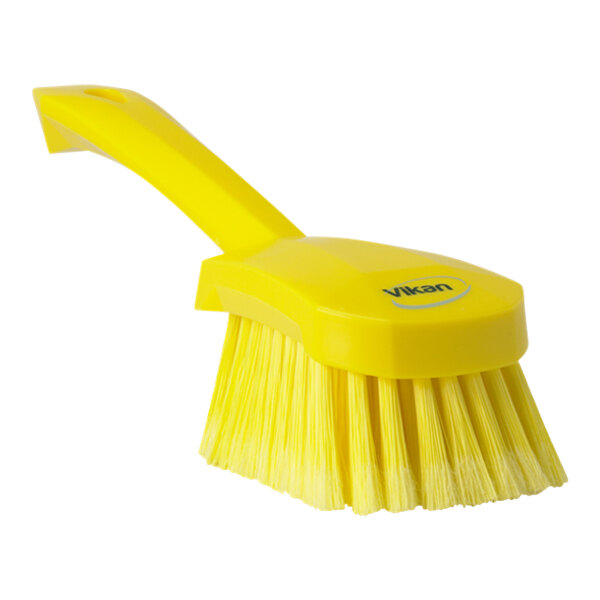 A close-up of a yellow Vikan washing brush with a short handle.