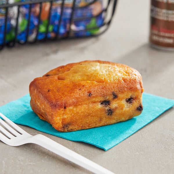 A piece of Ne-Mo's wild blueberry cake bread on a blue napkin next to a fork.