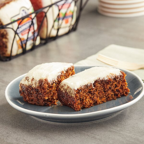Two Ne-Mo's Bakery individually wrapped carrot cake squares on a plate.