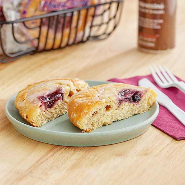 A plate with two Ne-Mo's Bakery Mixed Berry Danish pastries on it.