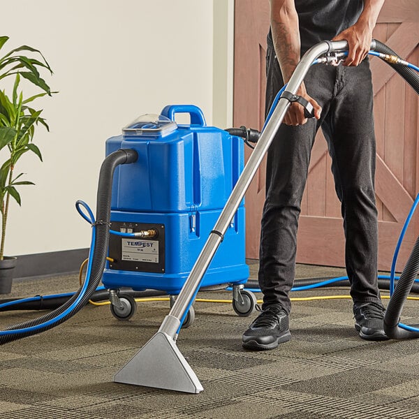 A person using a NaceCare carpet extractor to clean a carpet.