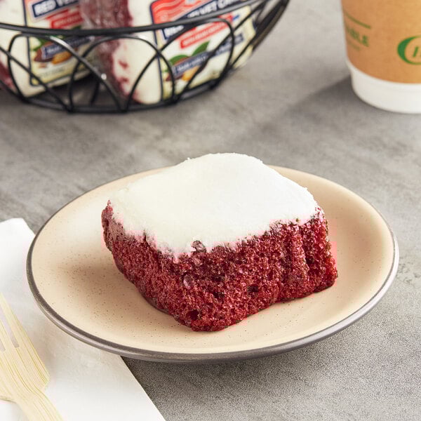 A Ne-Mo's Bakery individually wrapped red velvet cake square on a plate.
