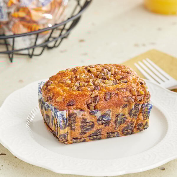 A Ne-Mo's Bakery individually wrapped sweet potato cake bread loaf on a plate.
