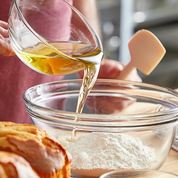 A person pouring Stratas BBS Flex shortening into a bowl of flour.