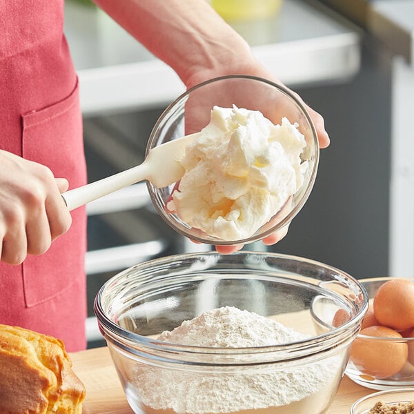 A person pouring Stratas Primex Z All-Purpose Shortening into a bowl of flour.