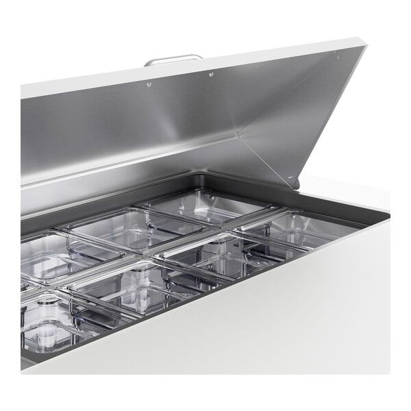 A silver stainless steel True sandwich prep table on a counter with clear containers inside.