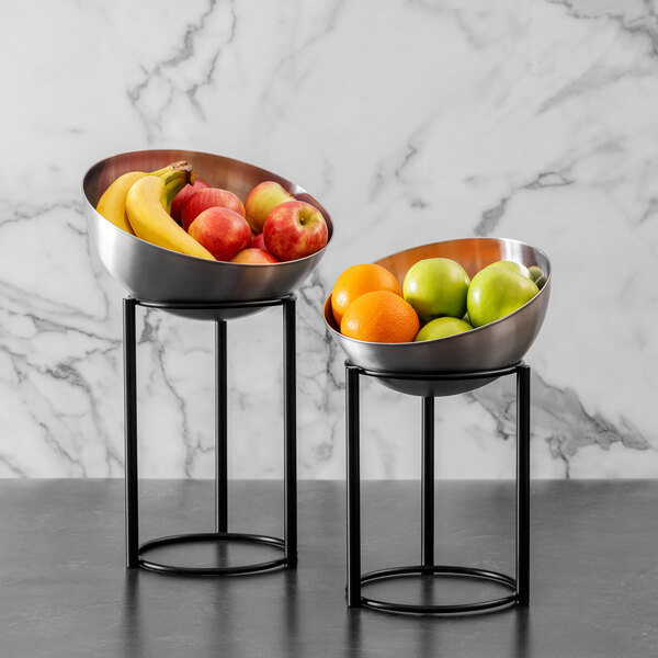 A stainless steel Arcoroc serving bowl filled with green apples, bananas, and red apples.