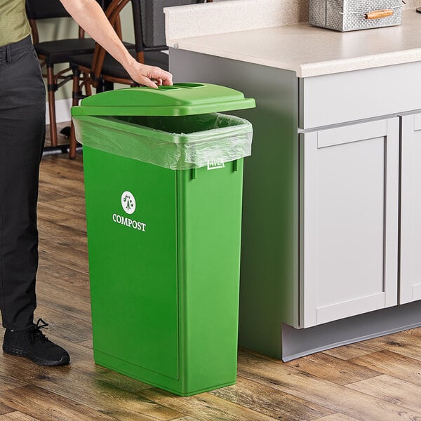 A woman standing next to a Lavex lime green rectangular compost receptacle with a flat lid.