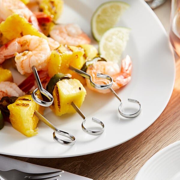 A white plate with Vollrath Stainless Steel Flat Skewers holding shrimp and pineapple.