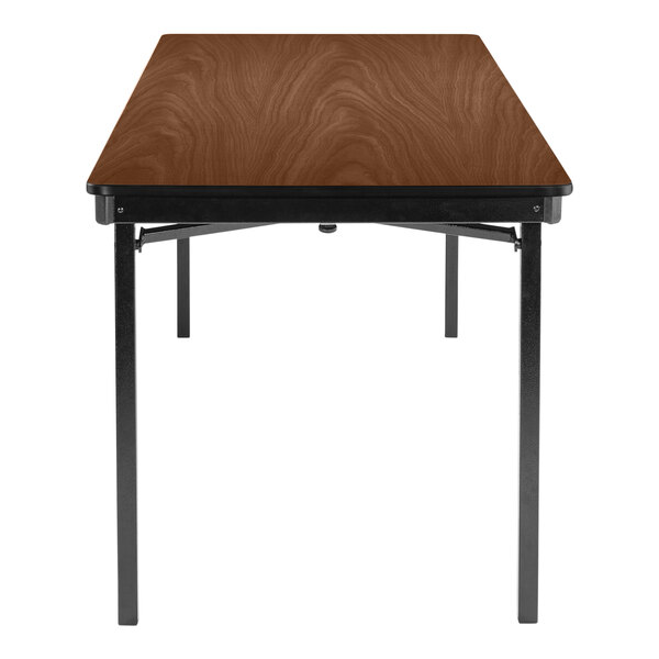 A brown rectangular National Public Seating table with a wooden top and black T-molded edges.