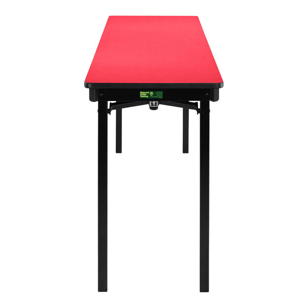 A red rectangular National Public Seating folding table with black legs.