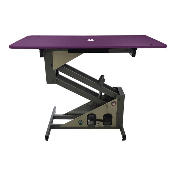 A purple Groomer's Best hydraulic grooming table with metal legs.