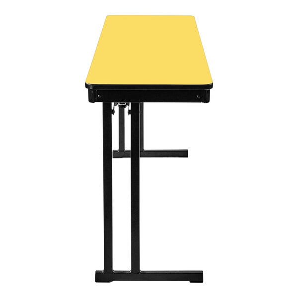A yellow rectangular National Public Seating folding table with black edges and cantilever legs.