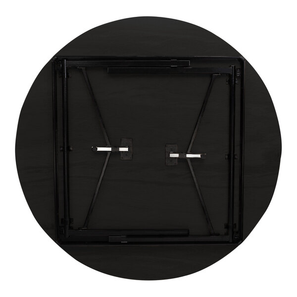 A round black plywood table with metal legs and a black frame.