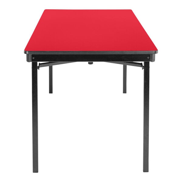 A rectangular red National Public Seating folding table with black T-mold edge and legs.
