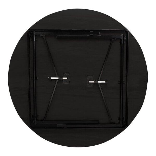 A National Public Seating round walnut folding table with a black T-shaped metal base.