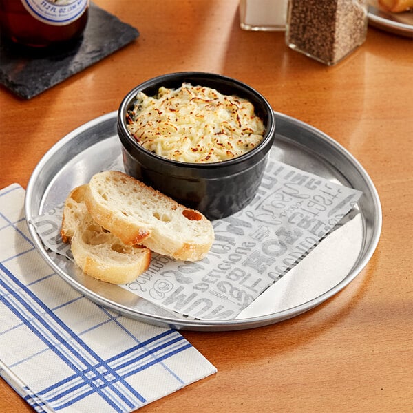 A bowl of food on a round aluminum sizzler platter.