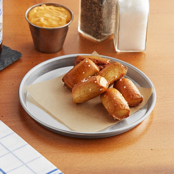 A Choice round aluminum sizzler platter with food on a table.