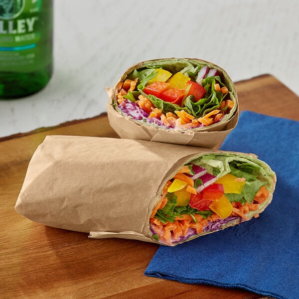 A table with two Bagcraft Dubl Shield sandwich wraps filled with vegetables and meat.