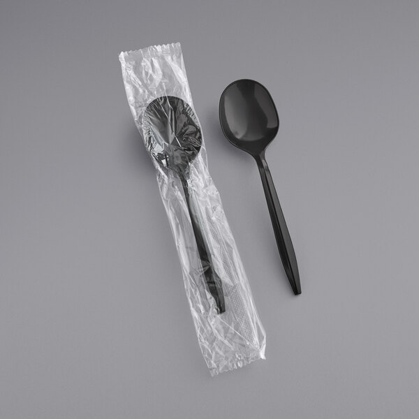A black plastic spoon in plastic packaging.