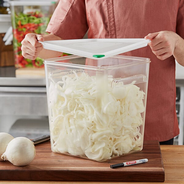 A man holding an Araven clear plastic container of shredded white onions.